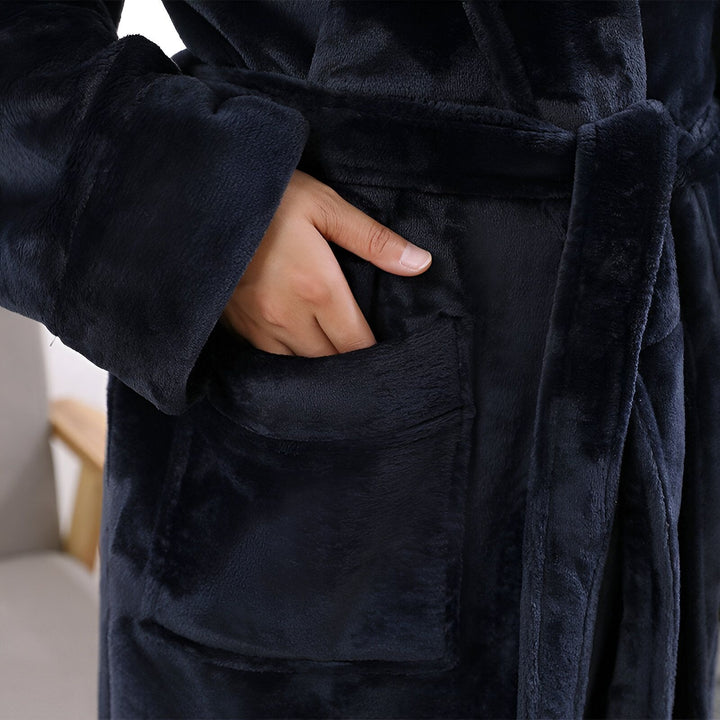 Détail d'un kimono de nuit bleu marine en tissu doux, avec une main dans la poche. Idéal pour se détendre à la maison. Découvrez notre collection de kimonos confortables.