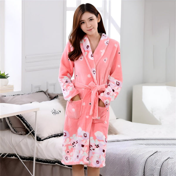 Femme portant un kimono rose à motifs floraux, avec ceinture, poches, manches longues. Fond de chambre à coucher. Kimono confortable et élégant.