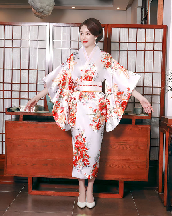Femme portant un kimono blanc à motifs floraux rouges. Élégance et tradition japonaises. Découvrez notre collection de kimonos uniques.