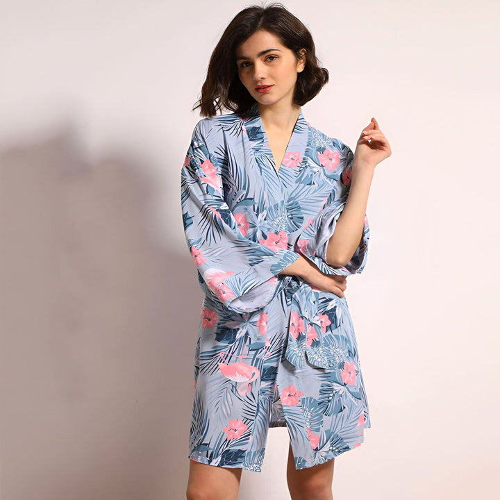 Femme portant un kimono bleu clair à motifs tropicaux de notre collection. Kimonos confortables et élégants en vente.