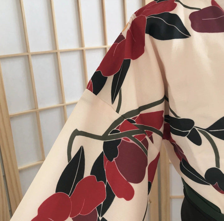 Détail d'un kimono à fleurs rouges et noires sur fond crème. Vêtement traditionnel japonais.