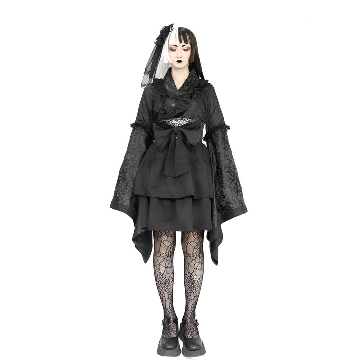 Femme portant un kimono noir gothique avec des motifs floraux, une jupe à volants, et une coiffure bicolore noire et blanche. Vêtements style kimono à vendre.