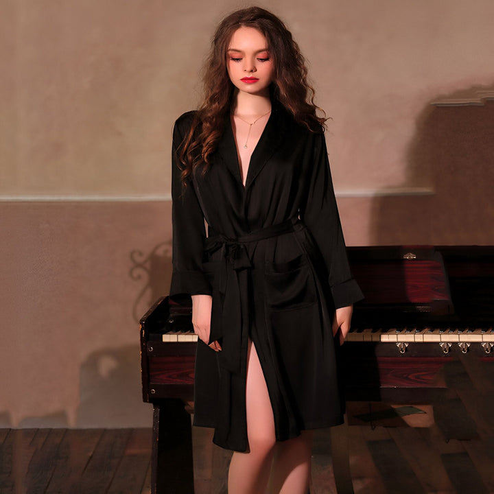 Femme portant un kimono noir élégant, avec une ceinture nouée. Idéal comme peignoir ou vêtement d'intérieur. Kimonos de luxe pour femme, disponibles dans notre boutique.