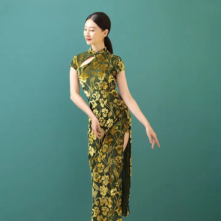 Femme portant une robe de style kimono longue, verte avec motifs floraux dorés. Robe fendue sur le côté et col montant original. Kimonos élégants et modernes à découvrir.