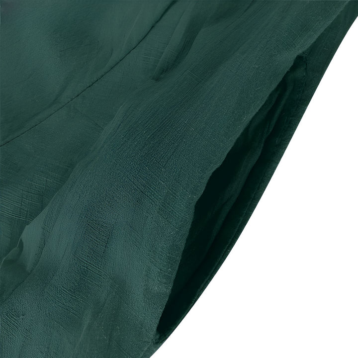 Détail d'un kimono vert foncé avec une poche. Texture du tissu en lin visible. Idéal pour ranger de petits objets avec style. Découvrez nos kimonos uniques.