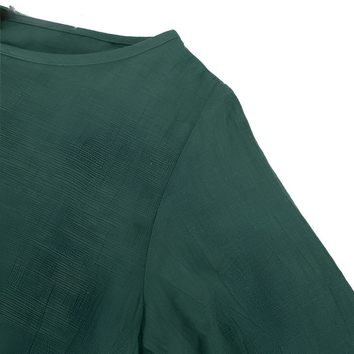 Détail d'un kimono vert foncé, mettant en valeur le tissu et la couture. Textile idéal pour une tenue élégante et confortable. Découvrez nos kimonos uniques.