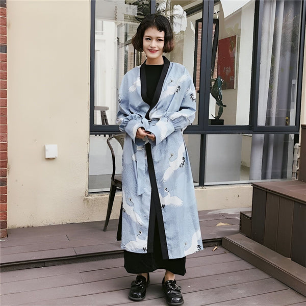 Femme portant un kimono bleu à motifs de grues blanches. Vêtements de style japonais à la mode. Boutique en ligne de kimonos.
