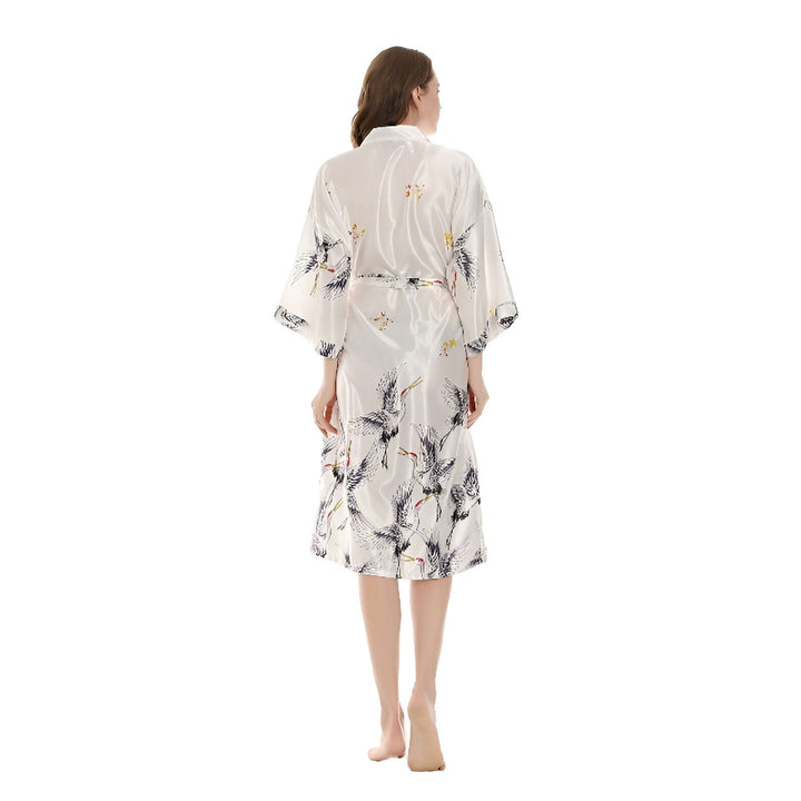 Femme portant un kimono blanc imprimé de grues. Vêtements de détente élégants, peignoir confortable. Découvrez notre collection de kimonos.