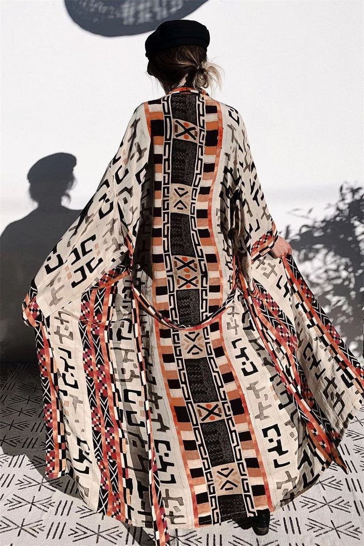 Kimono long imprimé ethnique porté par une femme vue de dos. Ce vêtement de style japonais est parfait pour un look bohème chic. Découvrez notre collection de kimonos uniques et originaux.