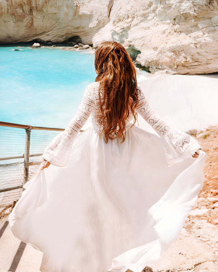 Femme portant un kimono blanc sur une plage de sable blanc avec une mer turquoise. Kimonos légers et élégants pour l'été.
