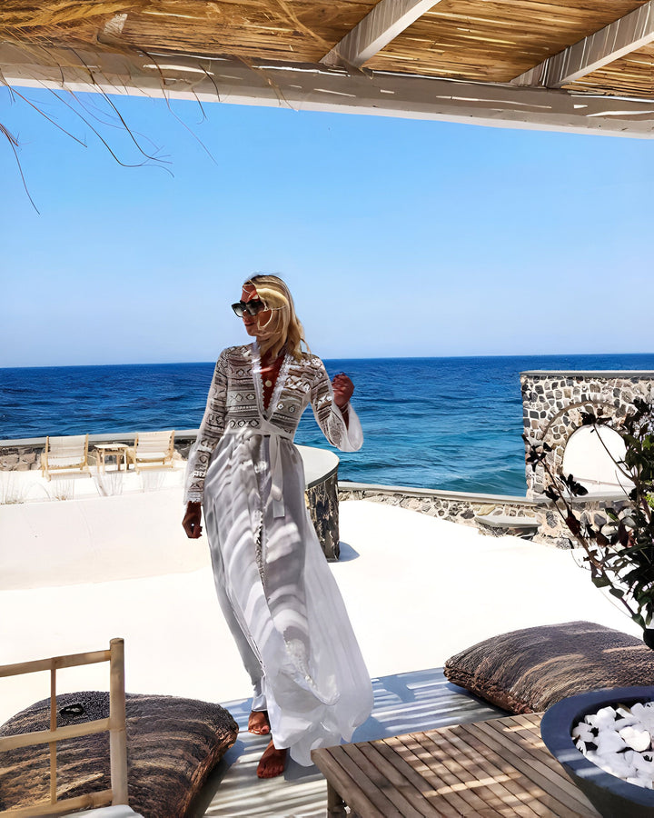 Femme portant un kimono blanc élégant avec vue sur la mer turquoise. Kimonos de luxe pour un style bohème chic. Découvrez notre collection de kimonos en ligne.
