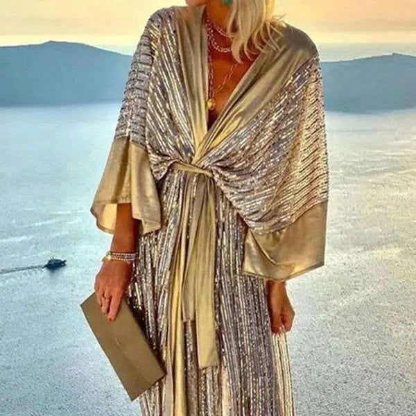 Femme portant un kimono doré scintillant, noué à la taille. Bijoux en or, pochette assortie. Kimonos de luxe pour femme disponibles à l'achat.