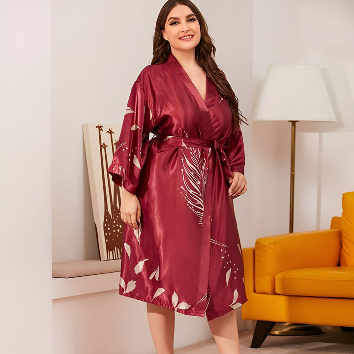 Femme souriante portant un kimono bordeaux avec motifs de feuilles. Peignoir élégant et confortable. Vente de kimonos pour femmes.