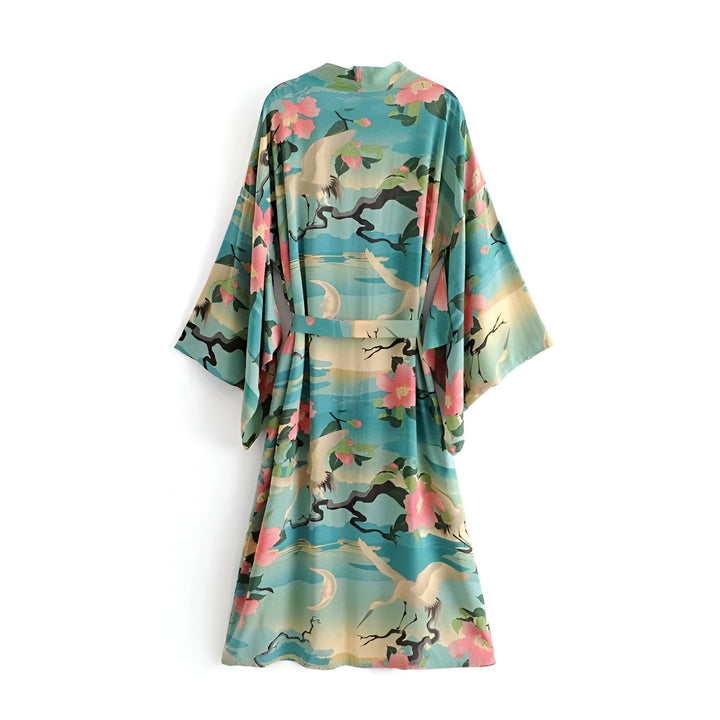 Kimono turquoise à motif floral et grues blanches. Vue arrière d'un peignoir japonais pour femme. Vêtement ample avec ceinture. Kimono à manches larges. Tunique légère et confortable. Mode asiatique.