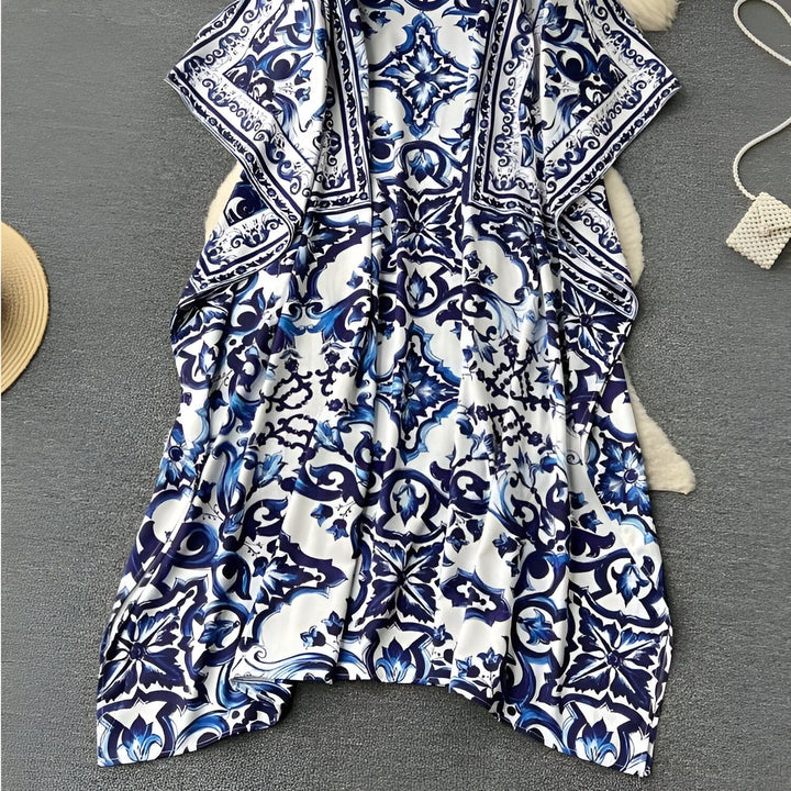 Kimono blanc à motifs bleus de style faïence. Vêtement d'intérieur chic et confortable, idéal pour la détente ou comme tenue d'été légère. Motifs floraux et géométriques détaillés.