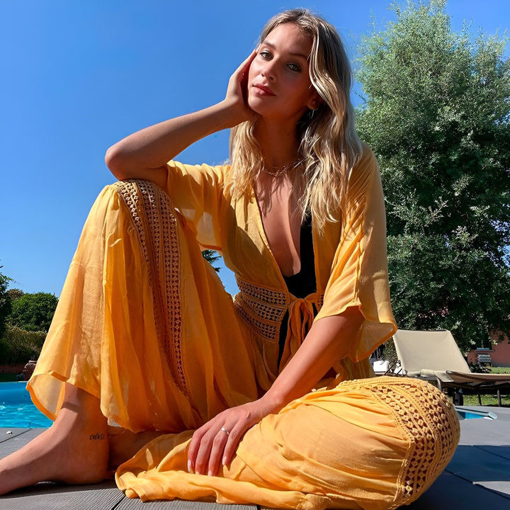 Femme élégante en kimono jaune près de la piscine. Vente de kimonos tendance pour l'été. Découvrez notre collection de kimonos légers et colorés.