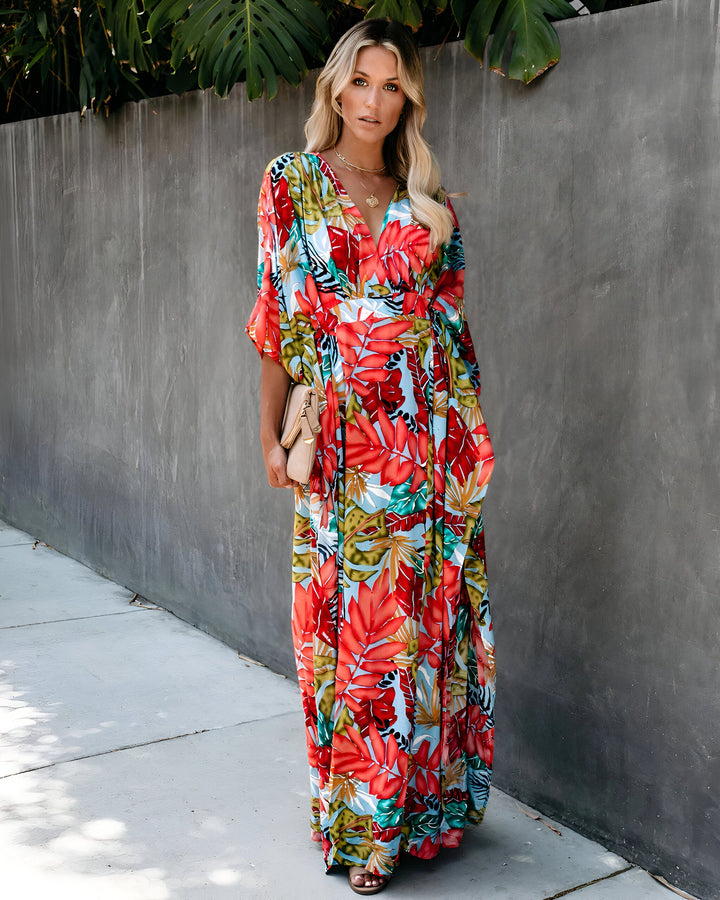 Femme blonde portant un kimono long à motifs floraux rouges et verts. Idéal pour l'été. Découvrez notre collection de kimonos uniques.