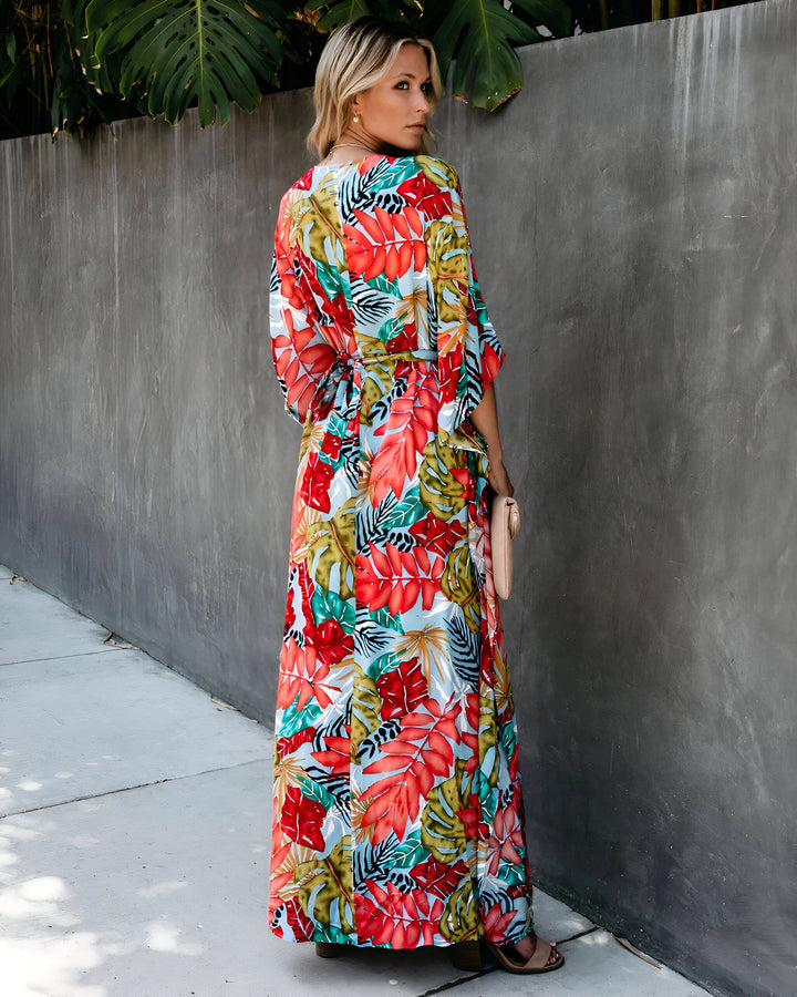 Femme portant un kimono long à motifs floraux tropicaux. Vêtement léger et coloré, idéal pour l'été. Kimonos de notre collection disponibles à l'achat.