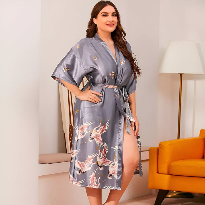Femme portant un kimono gris imprimé avec des grues et des fleurs. Élégant peignoir de style japonais. Vente de kimonos en ligne.
