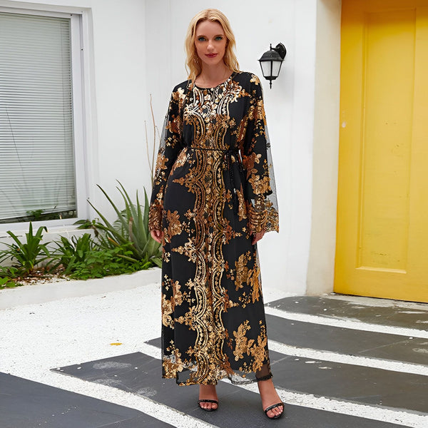 Femme blonde portant un kimono long noir avec des motifs dorés brillants et des manches évasées en tulle noir, collection de kimonos.