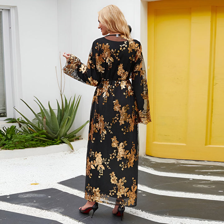 Femme portant un kimono noir long avec des motifs floraux dorés. Vue de dos, le kimono a des manches longues et une ceinture. Vente de kimonos en ligne.