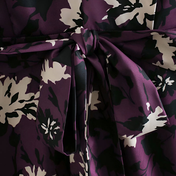 Détail d'un kimono violet avec un motif floral crème et noir et une ceinture nouée. Vêtement japonais élégant pour femme.