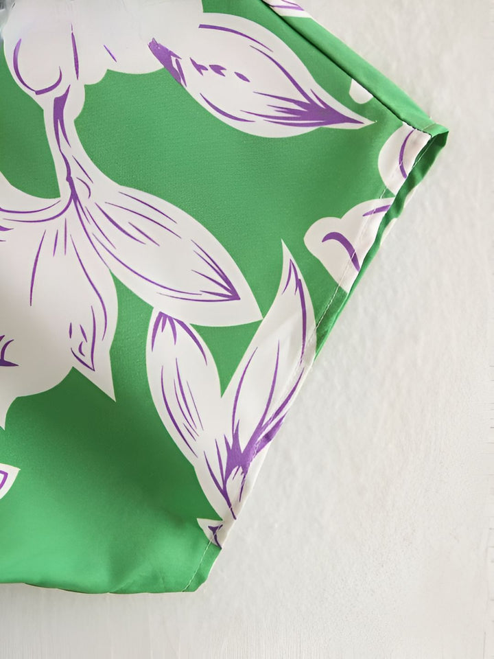 Détail d'un kimono vert avec motif floral blanc et violet. Vêtement léger et élégant, parfait pour toutes les occasions. Découvrez notre collection de kimonos uniques.