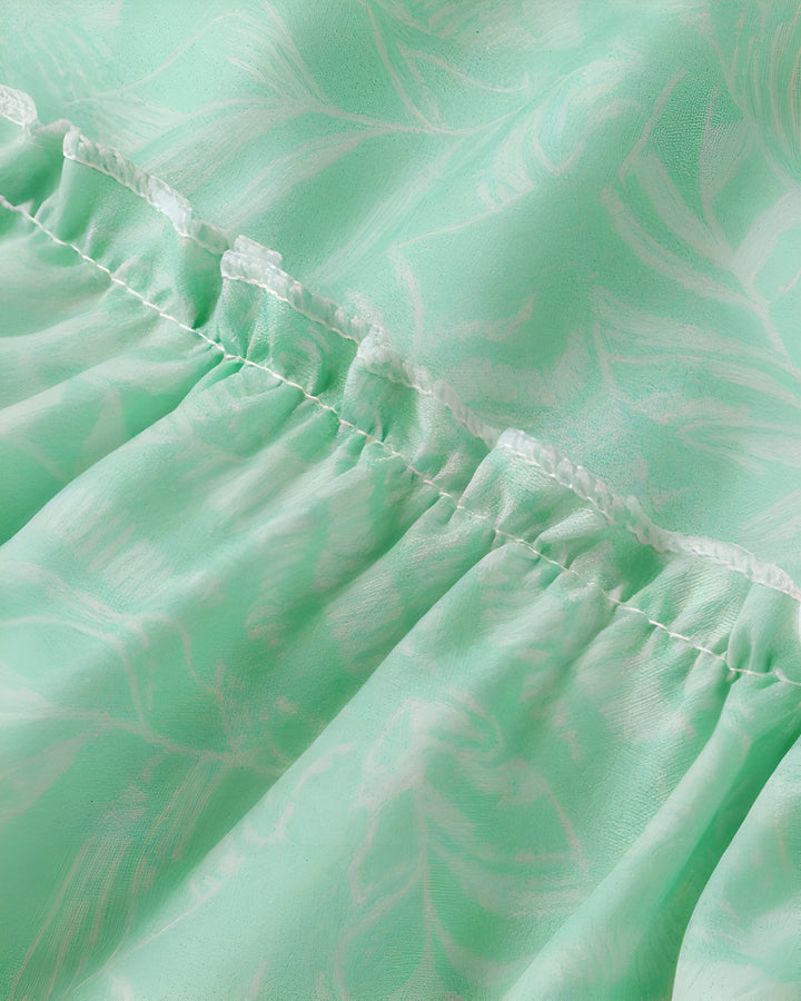 Détail d'un kimono vert d'eau avec motif de feuilles blanches et volants. Tissu léger et vaporeux. Vente de kimonos uniques.