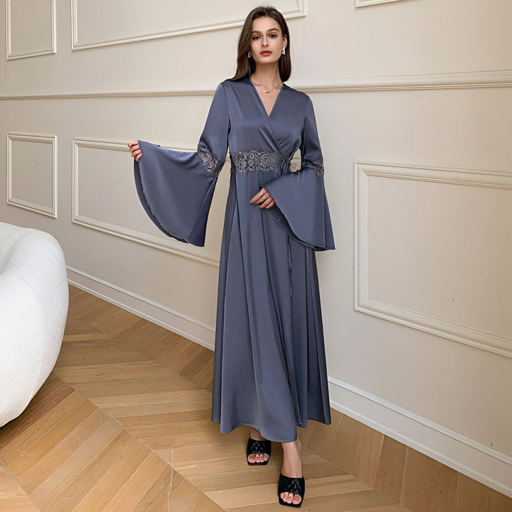 Femme portant un kimono long bleu avec des manches évasées et une ceinture en dentelle. Vêtements de style japonais.