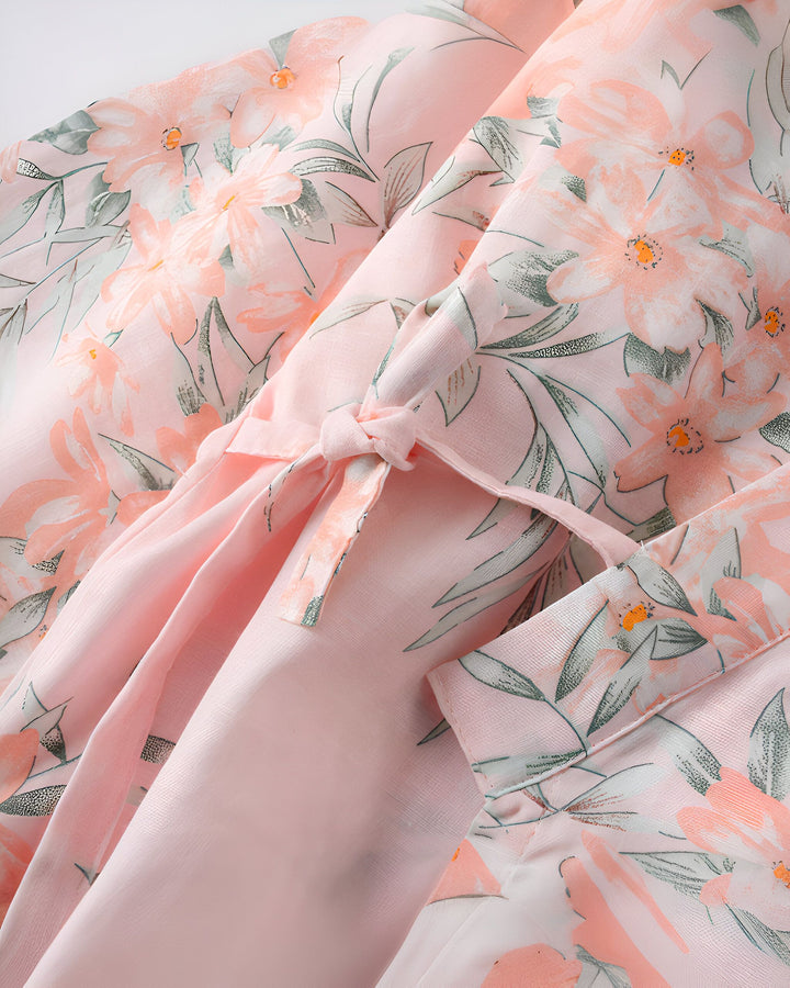 Détail d'un kimono rose à motifs floraux. Fermeture avec un nœud. Vêtements traditionnels japonais. Idéal pour un look élégant et confortable. Découvrez notre collection de kimonos uniques.