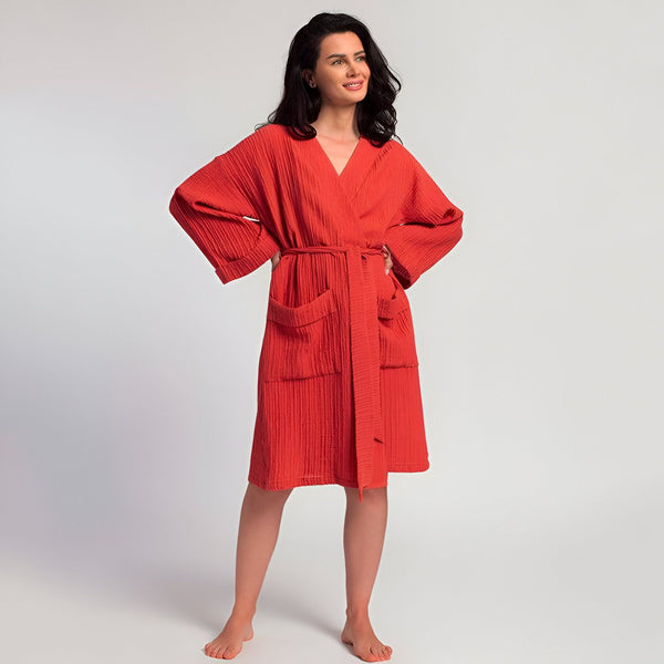 Femme portant un kimono rouge en coton gaufré avec ceinture, manches larges et poches. Vente de kimonos en ligne.