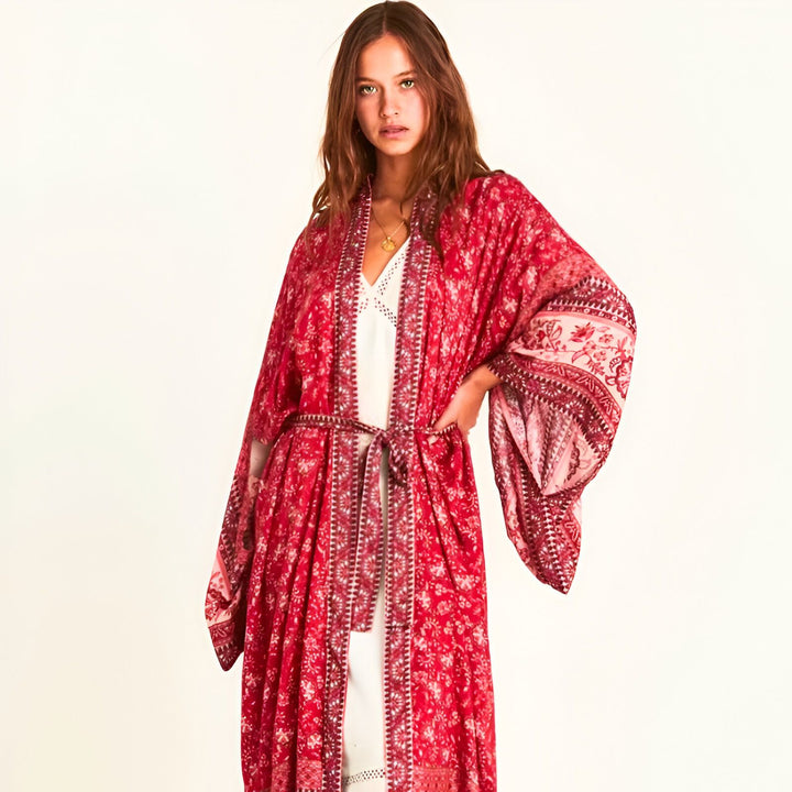Femme portant un kimono rouge fleuri avec ceinture. Kimono long et ample, manches évasées. Vêtements de style japonais. Collection de kimonos tendance.
