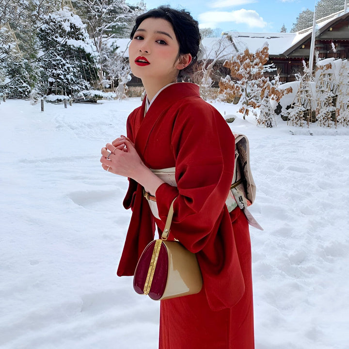 Femme en kimono rouge dans la neige. Vente de kimonos japonais traditionnels et modernes. Découvrez notre collection unique pour un style élégant et authentique.