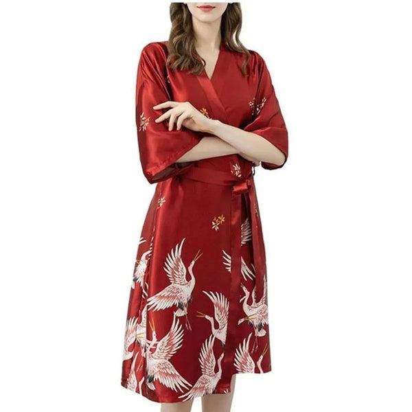 Femme portant un kimono rouge avec motif de grues. Kimono en soie, disponible à l'achat.