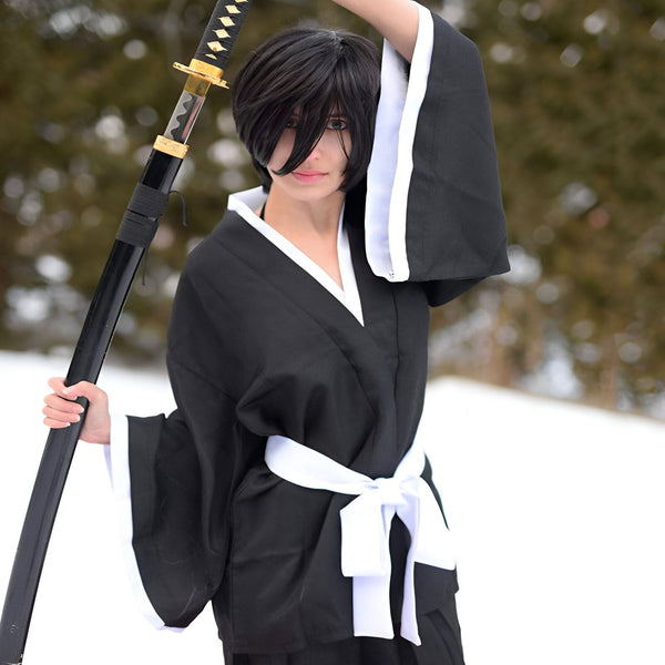 Femme en kimono noir et blanc tenant un katana. Découvrez notre collection de kimonos traditionnels japonais.