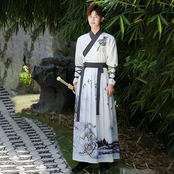 Un jeune homme en costume traditionnel asiatique blanc et gris, tenant une épée, devant un jardin luxuriant. Le vêtement est orné de motifs de tigres et d'oiseaux. Ambiance sereine et élégante.