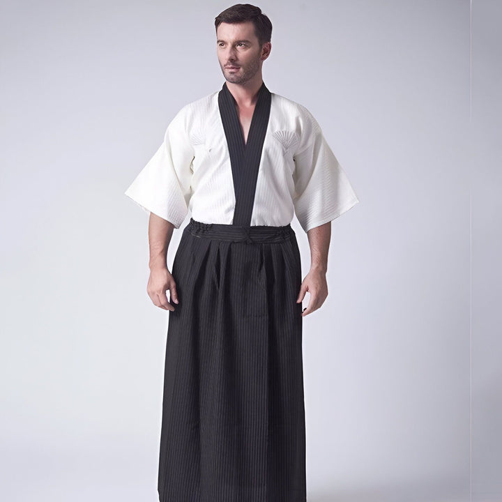 Homme portant un kimono traditionnel japonais, chemise blanche avec bordure noire et jupe hakama rayée noire. Vêtements de style kimono à vendre.