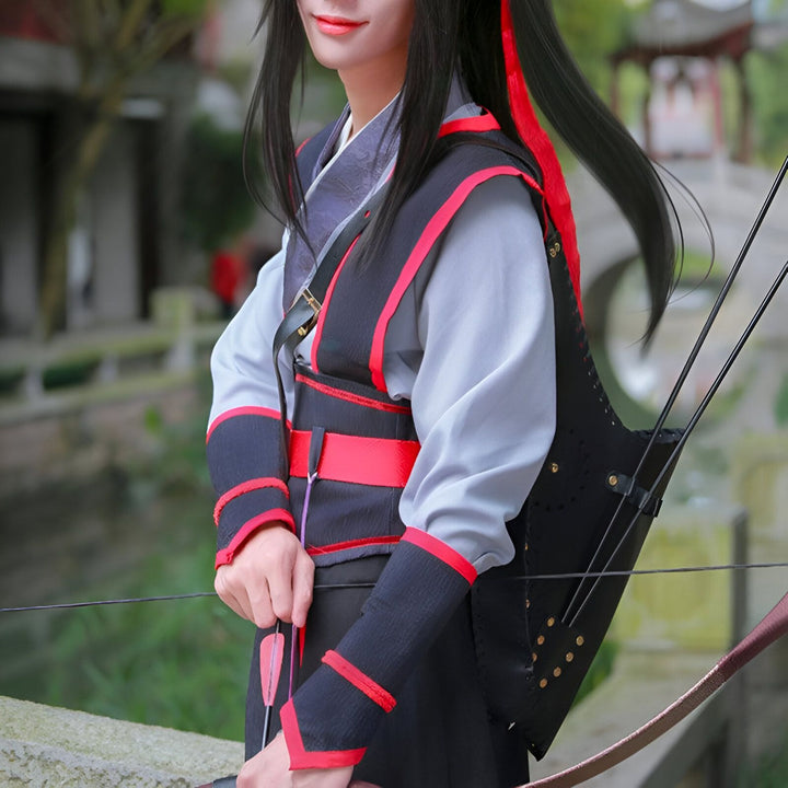 Cosplay de personnage asiatique tirant à l'arc, costume traditionnel gris et noir avec accents rouges, carquois en cuir, flèches, arc. Style manga/anime.