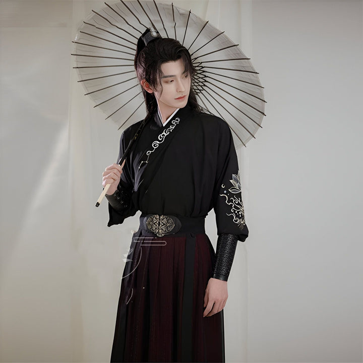 Homme portant un kimono noir traditionnel avec broderies florales et tenant un parasol. Vêtements de style asiatique disponibles à l'achat.