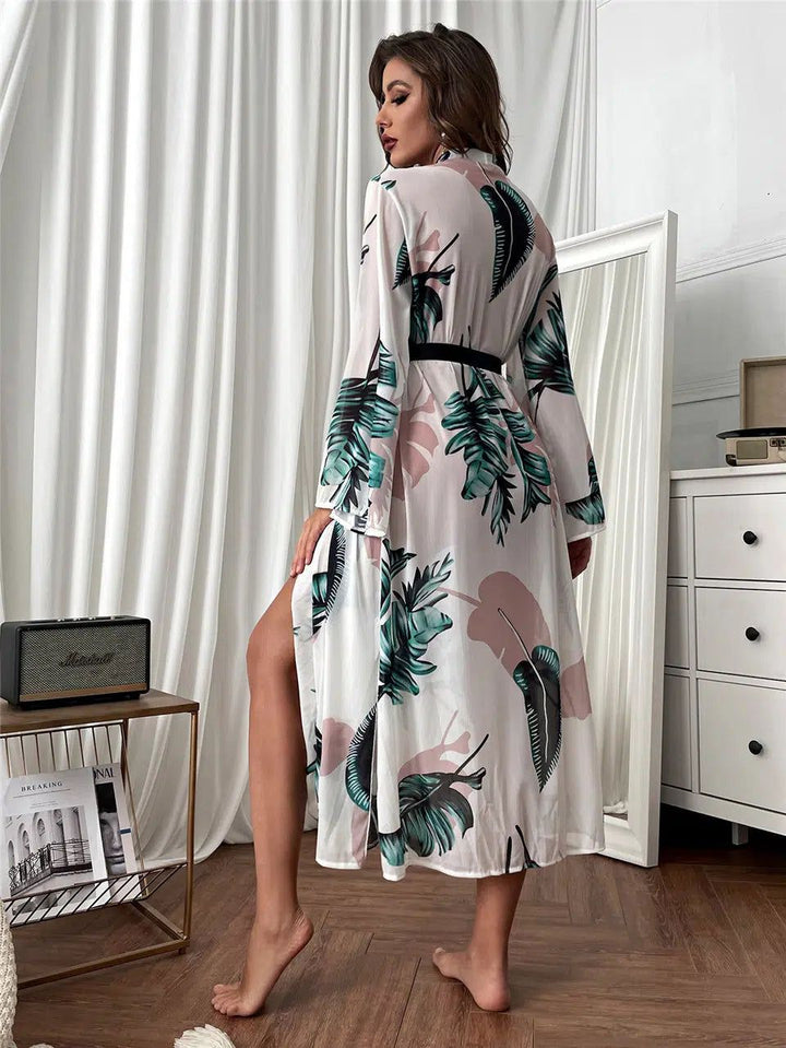 Femme portant un kimono long blanc à motifs de feuilles vertes et roses, avec une ceinture noire. Vente de kimonos.