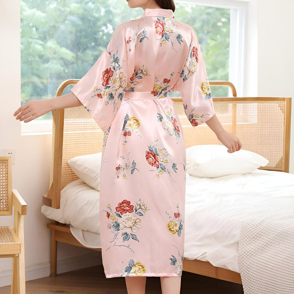 Femme portant un kimono rose à fleurs. Kimono élégant et confortable, parfait pour la détente à la maison. Découvrez notre collection de kimonos de qualité.