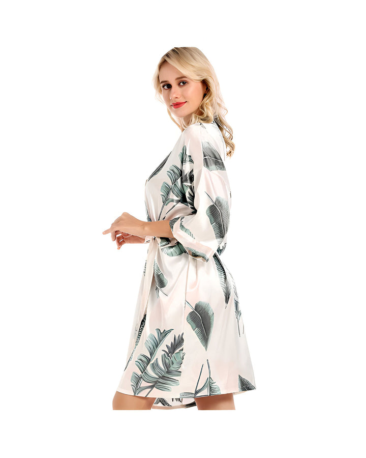 Femme blonde portant un kimono à motifs de feuilles vertes. Peignoir kimono élégant, idéal comme vêtement d'intérieur ou tenue décontractée. Découvrez notre collection de kimonos.