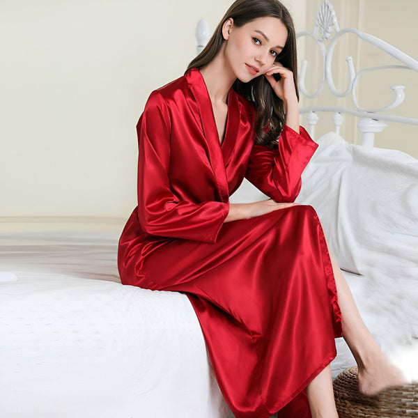 Femme élégante portant un kimono rouge en soie. Vente de kimonos de luxe en ligne. Peignoir long et soyeux pour femme. Mode japonaise, vêtement de détente.