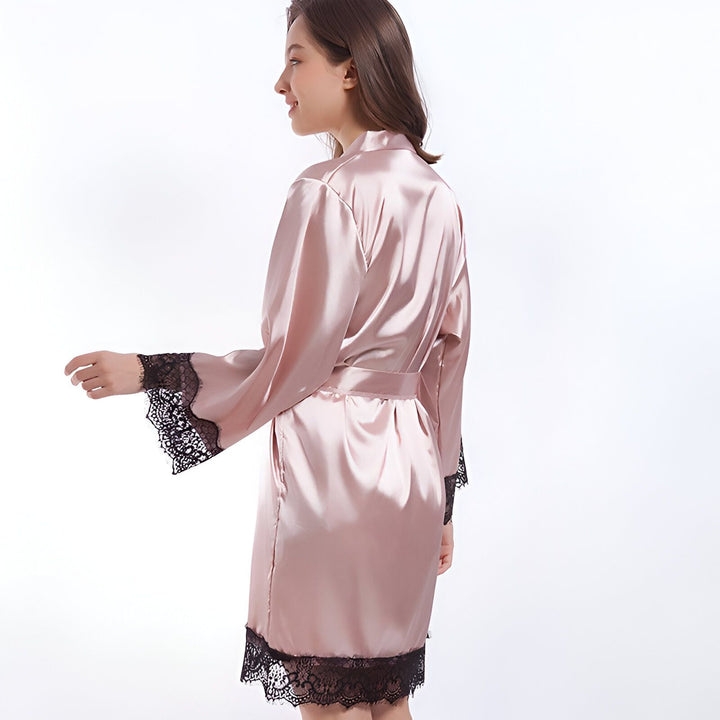 Kimono rose en satin avec bordure en dentelle noire. Vêtement d'intérieur élégant, peignoir confortable et féminin. Idéal pour se détendre avec style. Découvrez notre collection de kimonos.