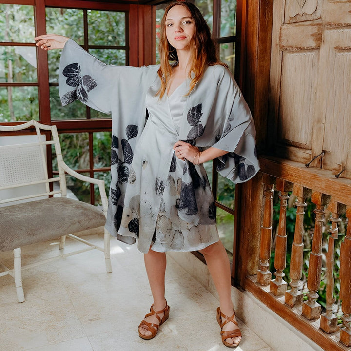 Femme portant un kimono gris à motifs de feuilles noires, manches larges. Vêtements de style japonais à vendre.