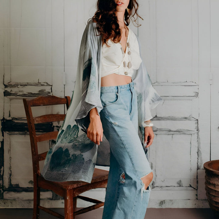 Femme portant un kimono à motifs floraux, un jean et un crop top blanc. Kimonos pour femmes disponibles à l'achat. Mode et style kimono.