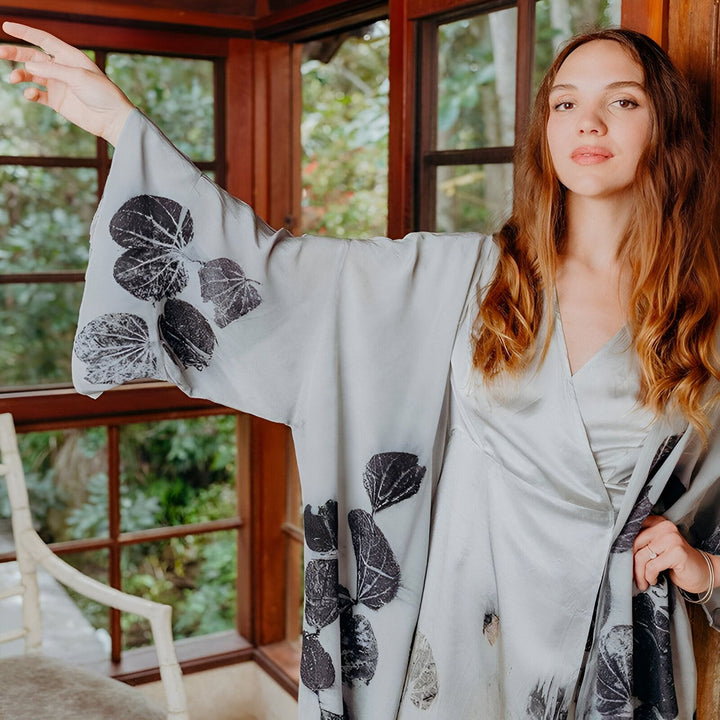 Femme portant un kimono gris à motifs de feuilles noires. Kimonos élégants et confortables à vendre.