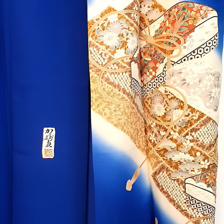 Détail d'un kimono japonais traditionnel. Motifs floraux et géométriques complexes. Tissu bleu royal et décorations ornementales. Vêtement japonais authentique.