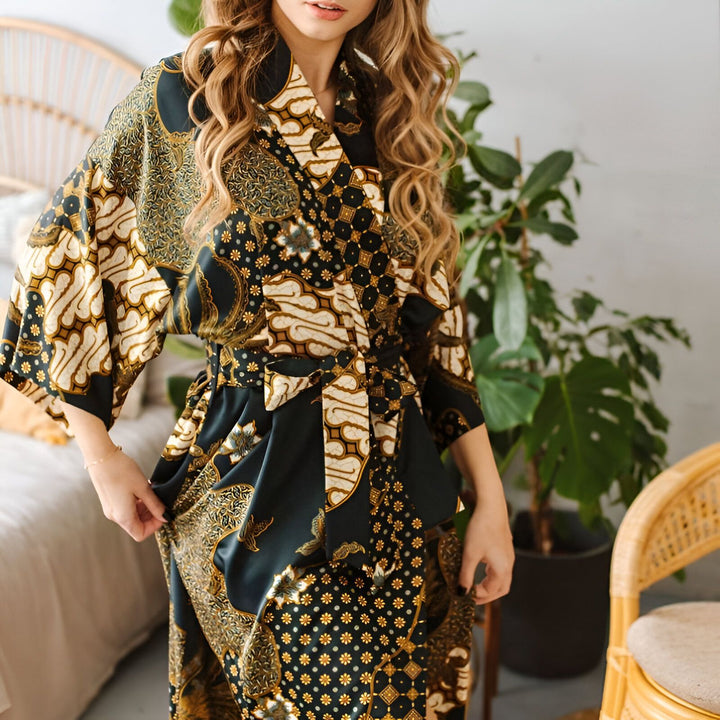Femme portant un kimono imprimé batik noir et or. Kimonos élégants et confortables disponibles à l'achat.