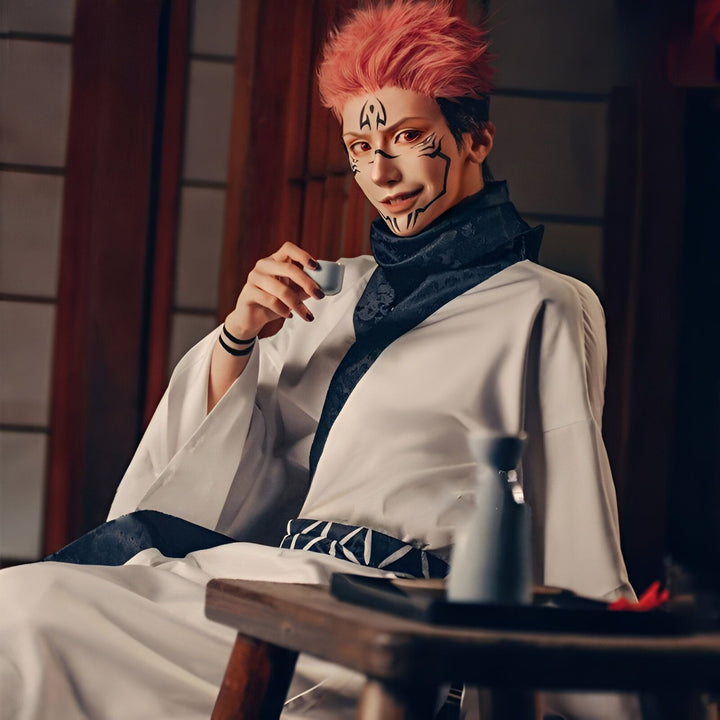 Homme en kimono blanc avec motifs faciaux, tenant une tasse. Vente de kimonos japonais traditionnels et modernes pour hommes et femmes.